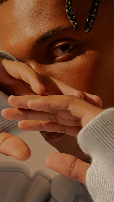 A man posing with his hands slightly in front of his face. A man posing with his hands slightly in front of his face.