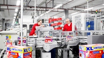 Due uomini lavorano alla linea di produzione Henkel che realizza pastiglie per lavastoviglie Due uomini lavorano alla linea di produzione Henkel che realizza pastiglie per lavastoviglie