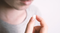 People taking or holding a white medicine pill in hand which help and protect from pandemic virus and relief them from unhealthy and sickness. studio close up shot and clear background.