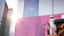 A man painting the outside of a building on scaffolding. A man painting the outside of a building on scaffolding.