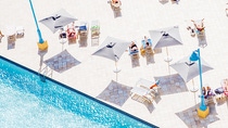 Mehrere Menschen sonnen sich neben einem Pool auf  Liegestühlen. Mehrere Menschen sonnen sich neben einem Pool auf  Liegestühlen.