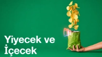 Tulum ve şapka giyen bir kadın çiftçi bir tablet tutuyor ve güneşli bir günde tarladaki bitkileri inceliyor. Resimdeki metinde şu yazıyor: “Yiyecek ve İçecek.”
