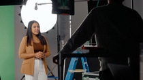 An employee is filmed in a professional studio setting, sharing her experiences and perspectives. Camera equipment, lighting, and crew members are visible, offering a behind-the-scenes view of video production at BASF.