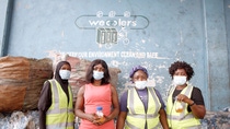 Four women stand in front of a wall and hold placik bottles with oil in their hands. Four women stand in front of a wall and hold placik bottles with oil in their hands.