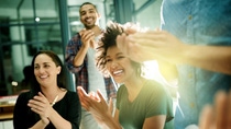 Shot of a team of creative businesspeople applauding an achievement  while working late in the boardroom