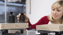 Lady in a red sweater adding weights to a scale Lady in a red sweater adding weights to a scale