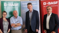 Four people standing in front of BASF banners