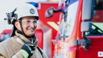 Feuerwehrkraft der BASF im Einsatzbereich vor Einsatzfahrzeugen – Link zu Werksfeuerwehr-Jobs.