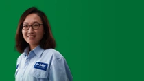 一名身穿浅蓝色衬衫的中国女性巴斯夫员工位于绿色背景前，头部附近环绕着光环。 