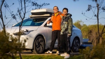 Two man standing in front of a white electric car. Two man standing in front of a white electric car.