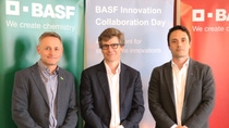Three people standing in front of 3 BASF banners