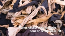 Gros plan sur une grande pile de pièces textiles usagées de différentes couleurs, emmêlées.&nbsp;