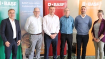 Six people standing in front of BASF banners