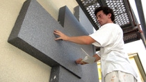 Man in a white tee shirt applying insulation Man in a white tee shirt applying insulation
