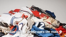 Uma pilha de camisas esportivas usadas em várias cores. 