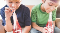 Header image for BASF adhesives: boys drinking soda together, holding glass bottles with transparent labels