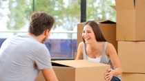 Happy couple or marriage lifting boxes moving home