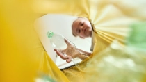 Low angle view of girl throwing a bottle in a plastic bag