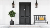 Stylish black front door of modern house with white walls, door mat, tree in pot, black bench, stairs and lamps. 3d rendering Stylish black front door of modern house with white walls, door mat, tree in pot, black bench, stairs and lamps. 3d rendering