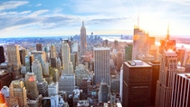 View overlooking a large city on a bright, sunny day, looking across the roofs of many high skyscrapers