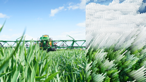 Agricultural vehicle in a field, partially pixelated Agricultural vehicle in a field, partially pixelated