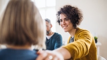 Serious men and women sitting in a circle during group therapy, supporting each other. Serious men and women sitting in a circle during group therapy, supporting each other.