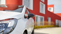 White car in front of a red building White car in front of a red building