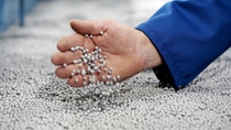 Aufgeschäumtes Neopor® ist federleicht: Mit einem Griff in die silbergrauen Kugeln kontrolliert ein Mitarbeiter das Ergebnis des Vorschäumens. Aufgeschäumtes Neopor® ist federleicht: Mit einem Griff in die silbergrauen Kugeln kontrolliert ein Mitarbeiter das Ergebnis des Vorschäumens.
