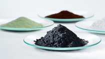 La clave de los potentes materiales de las baterías: Materiales activos catódicos precursores (polvo verde y marrón), carbonato de litio (polvo blanco) y materiales activos catódicos (polvo negro).