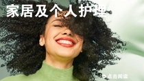 一个微笑的黑色卷发女性。图像上的文字为“家居与个人护理”。 