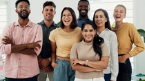 A group of young talents stand in a bright office room and smile at the camera. A group of young talents stand in a bright office room and smile at the camera.