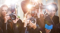 Portrait of paparazzi in a row with cameras and microphone