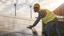 Man working for solar panels and wind turbines - Renewable energy concept - Focus on male worker hands