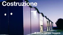 Esterni di un edificio moderno al crepuscolo con le luci accese.  Il testo sull’immagine recita: “Edilizia” Esterni di un edificio moderno al crepuscolo con le luci accese.  Il testo sull’immagine recita: “Edilizia”