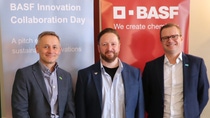 Three people standing in front of BASF banners