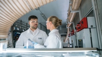 Two BASF bio-tech scientists in lab coats working together Two BASF bio-tech scientists in lab coats working together