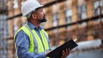 Shot of a contractor filling out paperwork at a construction site. Shot of a contractor filling out paperwork at a construction site.