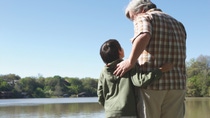 Grandfather and grandson standing on wooden dock Grandfather and grandson standing on wooden dock