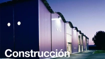 Exterior de un edificio moderno al atardecer con las luces encendidas.&nbsp; En el texto de la imagen pone: “Construcción”