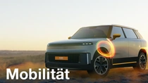 Ein hellfarbenes SUV steht in einer Wüstenlandschaft bei Sonnenuntergang, mit einem leuchtenden Lichtring-Effekt über dem Vorderrad. Der Text lautet: „Transport."