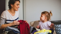 Mother and her daughter folding laundry together