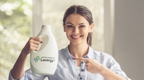 Beautiful young woman is holding a fabric softener over the basin with laundry, showing Ok sign, looking at camera and smiling; Shutterstock ID 510915580; Thema: Laundry Beautiful young woman is holding a fabric softener over the basin with laundry, showing Ok sign, looking at camera and smiling; Shutterstock ID 510915580; Thema: Laundry