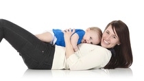Happy woman laying down holding cute/happy baby laying on her chest  Happy woman laying down holding cute/happy baby laying on her chest