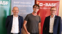 Three people standing in front of BASF banners Three people standing in front of BASF banners