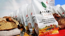 bread product display in white packaging with green bird. 