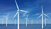 White wind turbine in water with blue skies  White wind turbine in water with blue skies