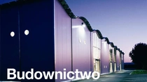 Nowoczesny budynek z włączonymi światłami o zmierzchu.  Tekst na zdjęciu brzmi: „Budownictwo”