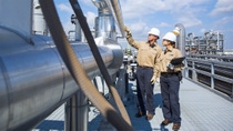 Two BASF employees inspecting pipe line in white hard hats