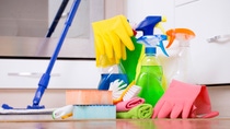 Cleaning supplies and equipment on kitchen floor with oven in background