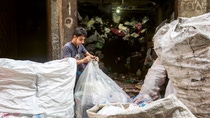 Garbage collector, on the streets of Cairo, tying a plastic bag. Garbage collector, on the streets of Cairo, tying a plastic bag.